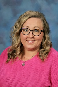 Teacher smiling against a blue background