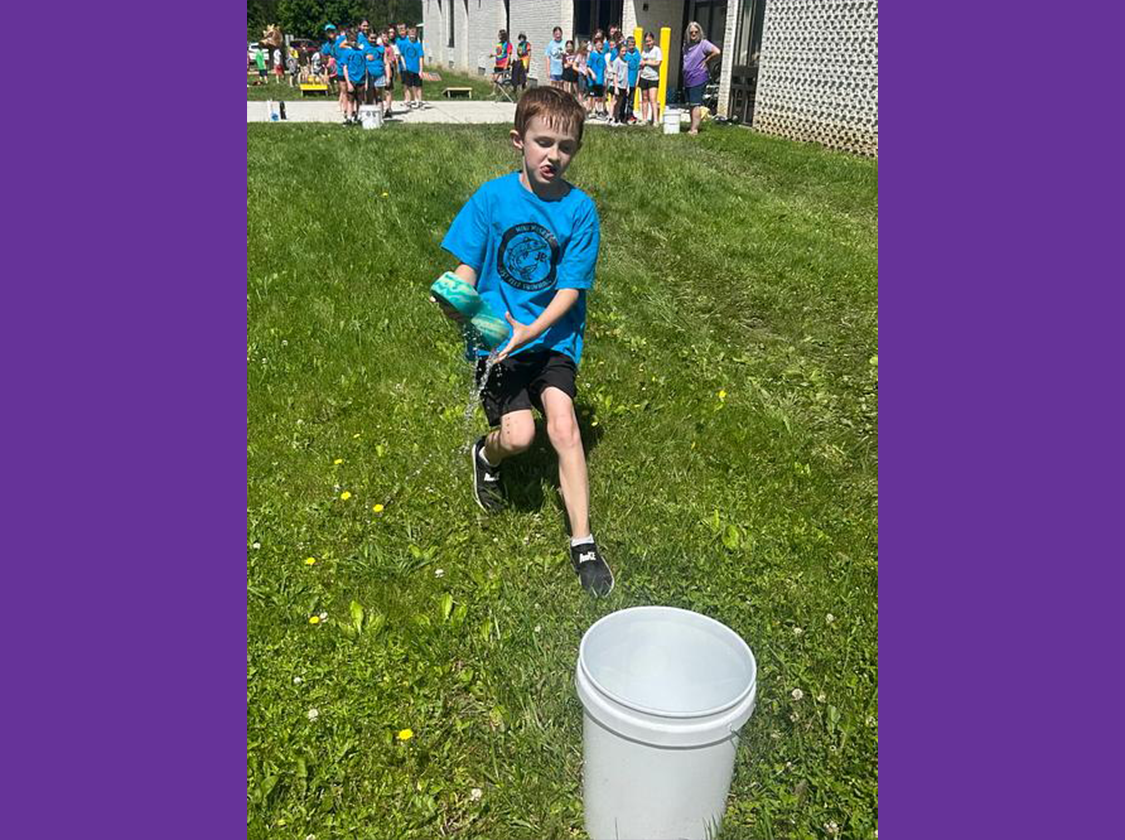 Field Day 2026 Students playing empty the water bucket with a sponge