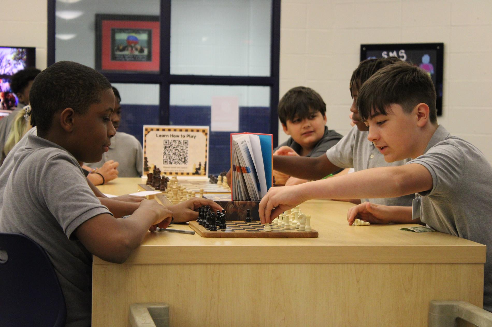 Kids playing chess in the library 