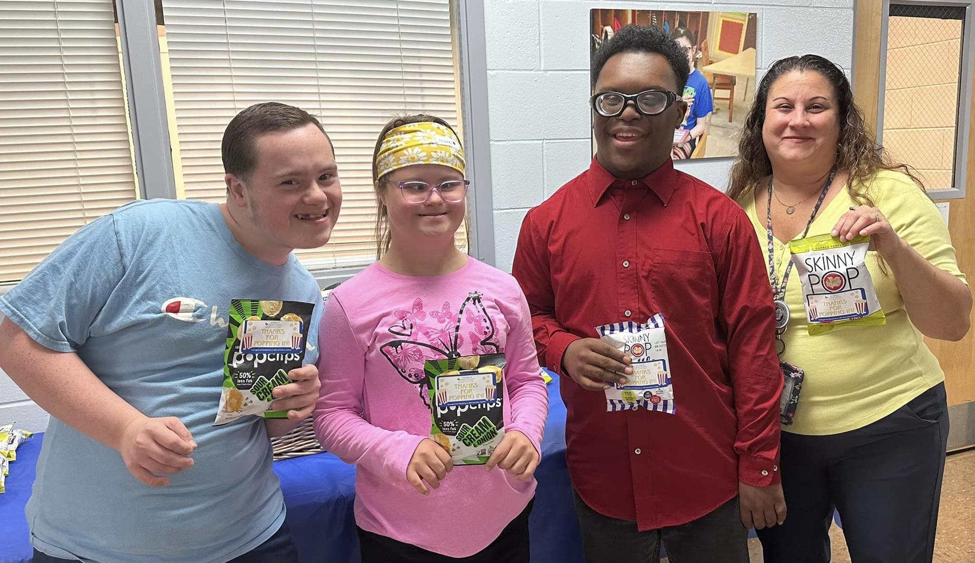 Students and Secondary Lead Teacher holding pocorn bags.