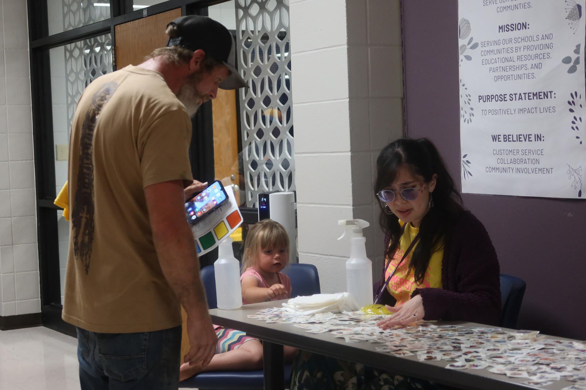An ROE employee gives a girl a temporary tattoo