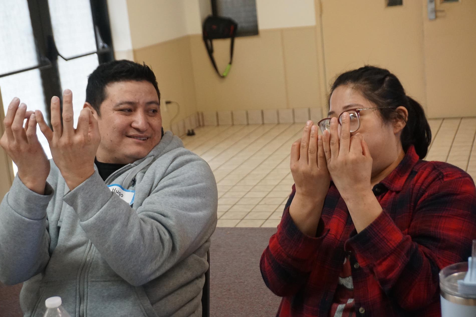 Hispanic Mom & Dad learning sign language