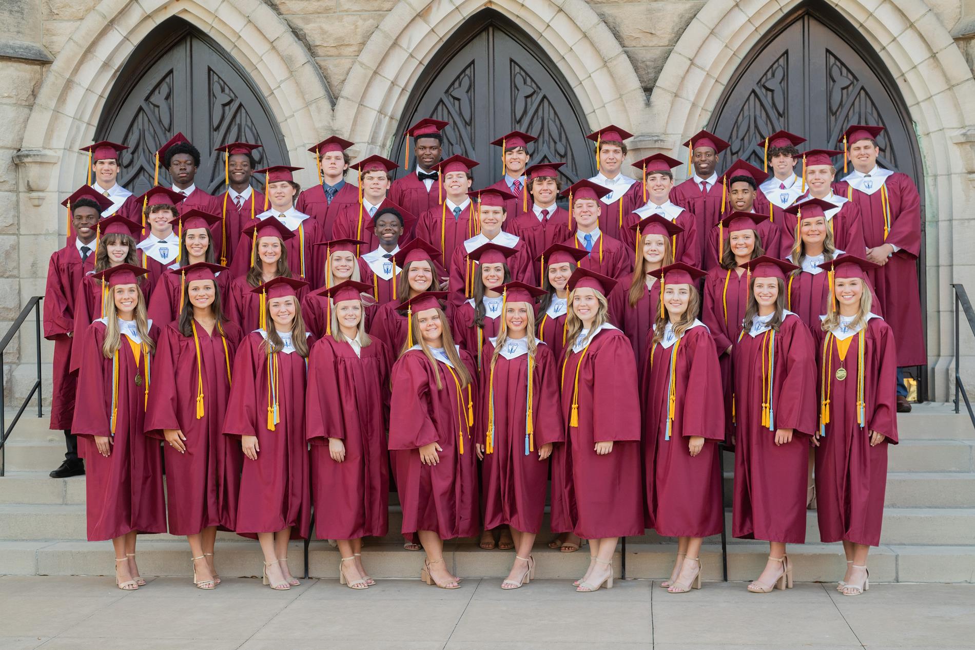 Class of 2026 in Cap and Gown in front of Forst Baptist Church