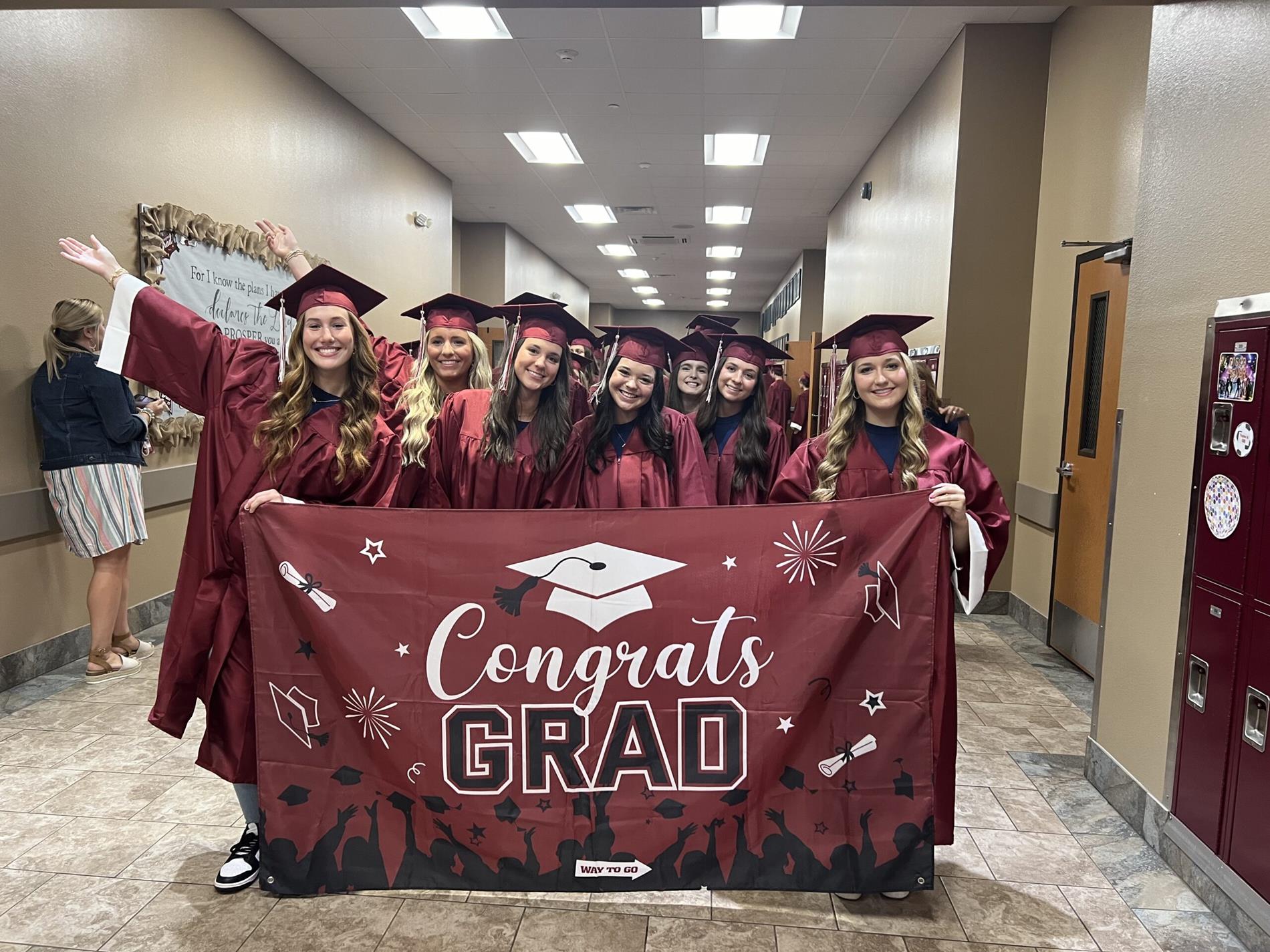 graduates holding congratulations banner