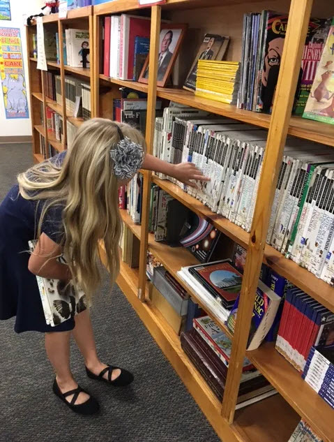 young girl choosing book