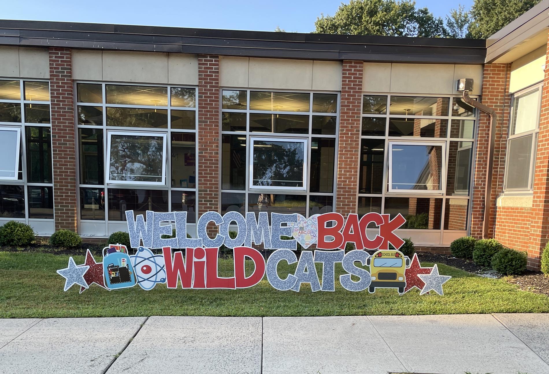 Large welcome back lawn sign at front of school