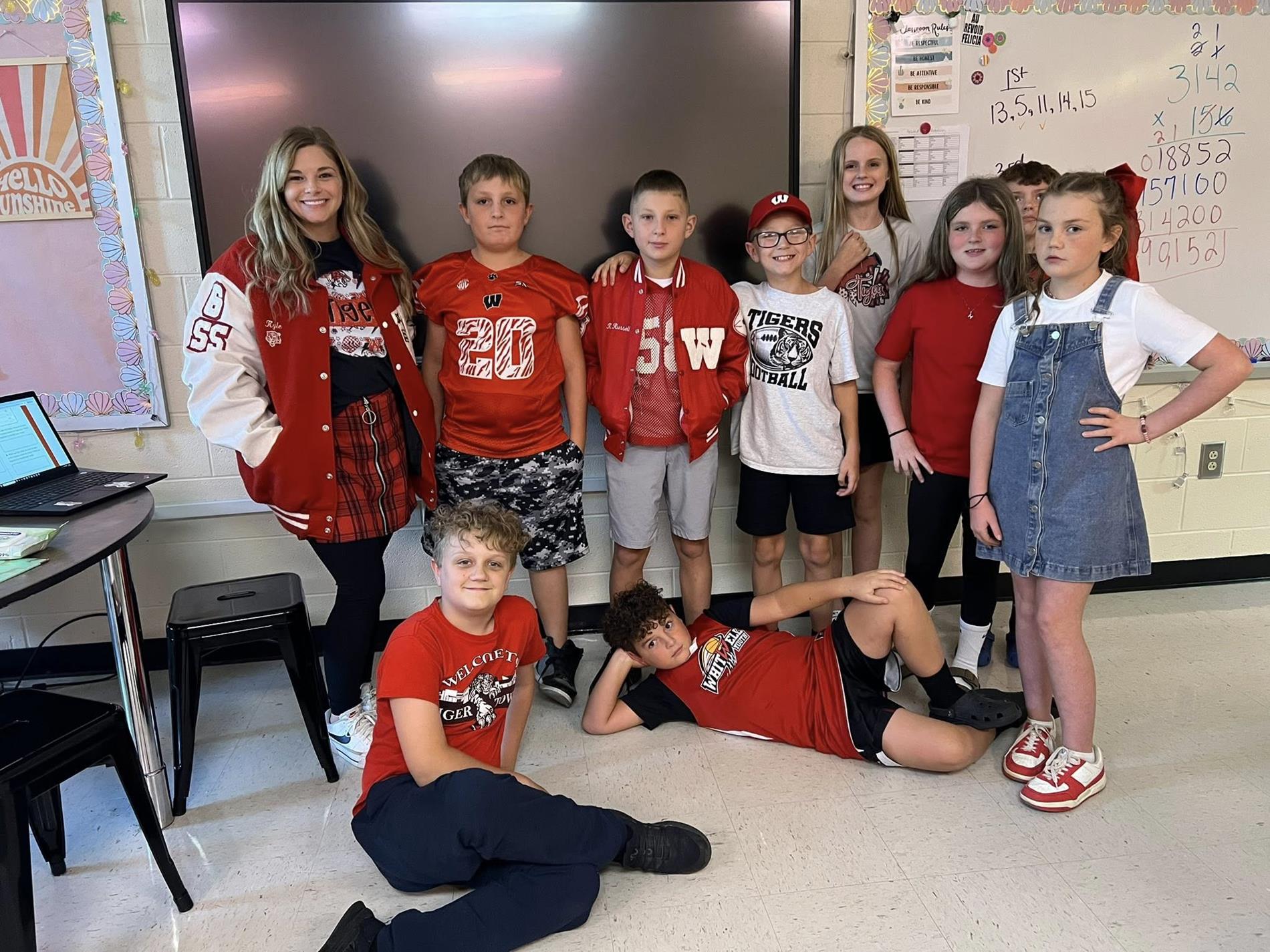 Group of students with their teacher dressed in Tiger attire for HOCO '25!
