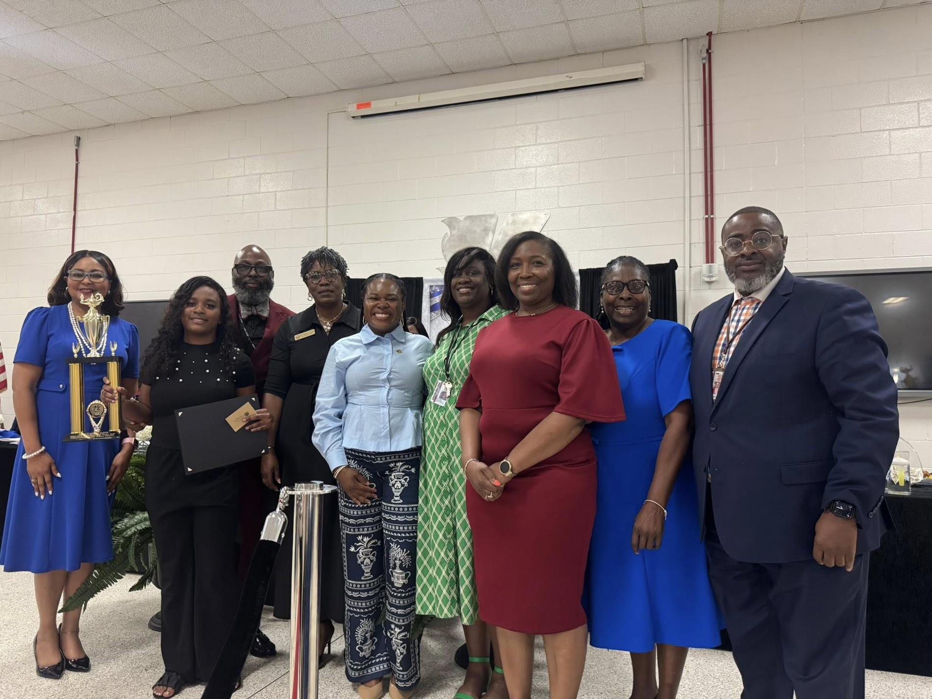 people standing together. one is receiving an award 