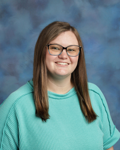 teacher smiling against blue background