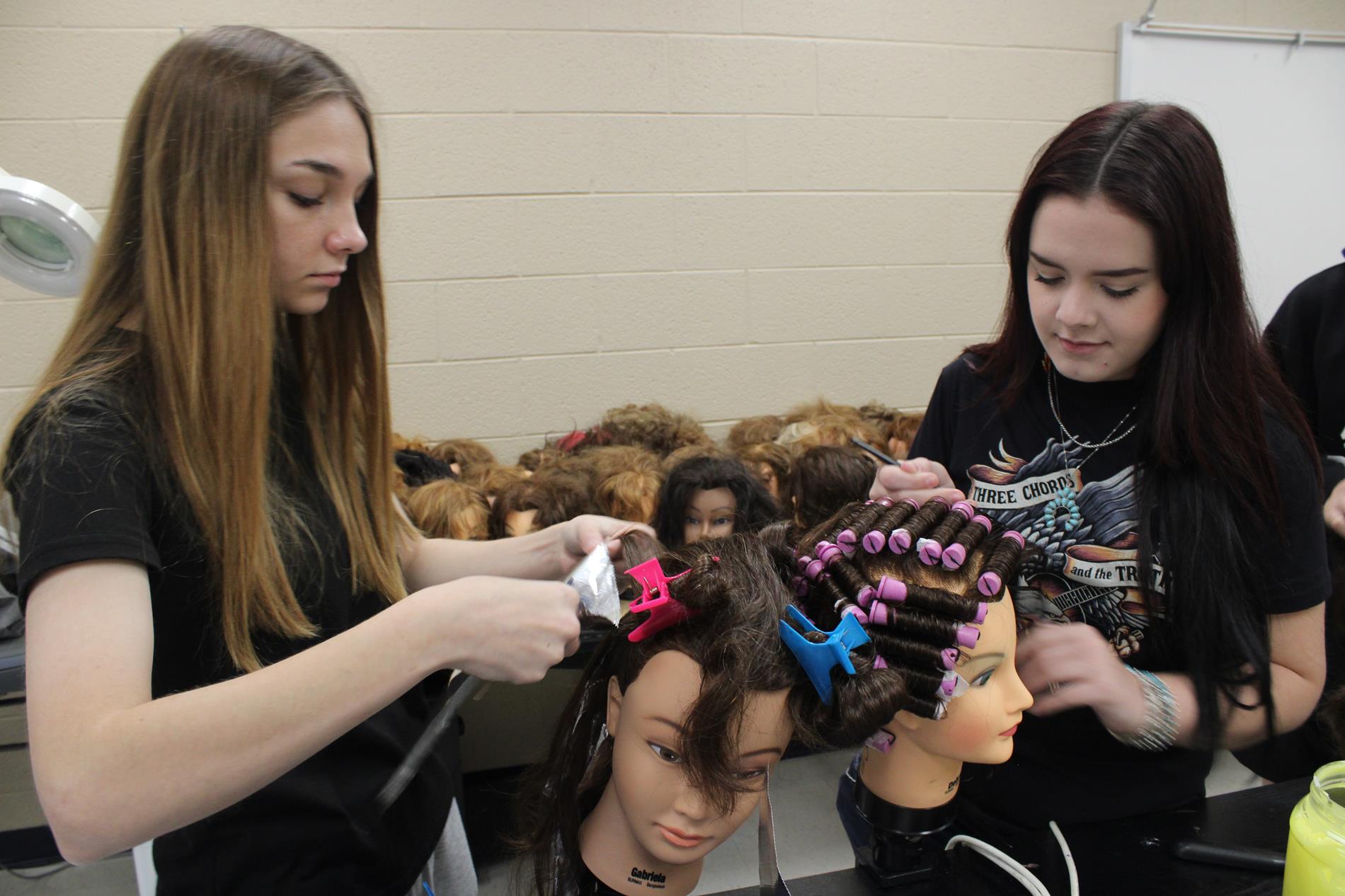 students working on mannequins in Cosmetology