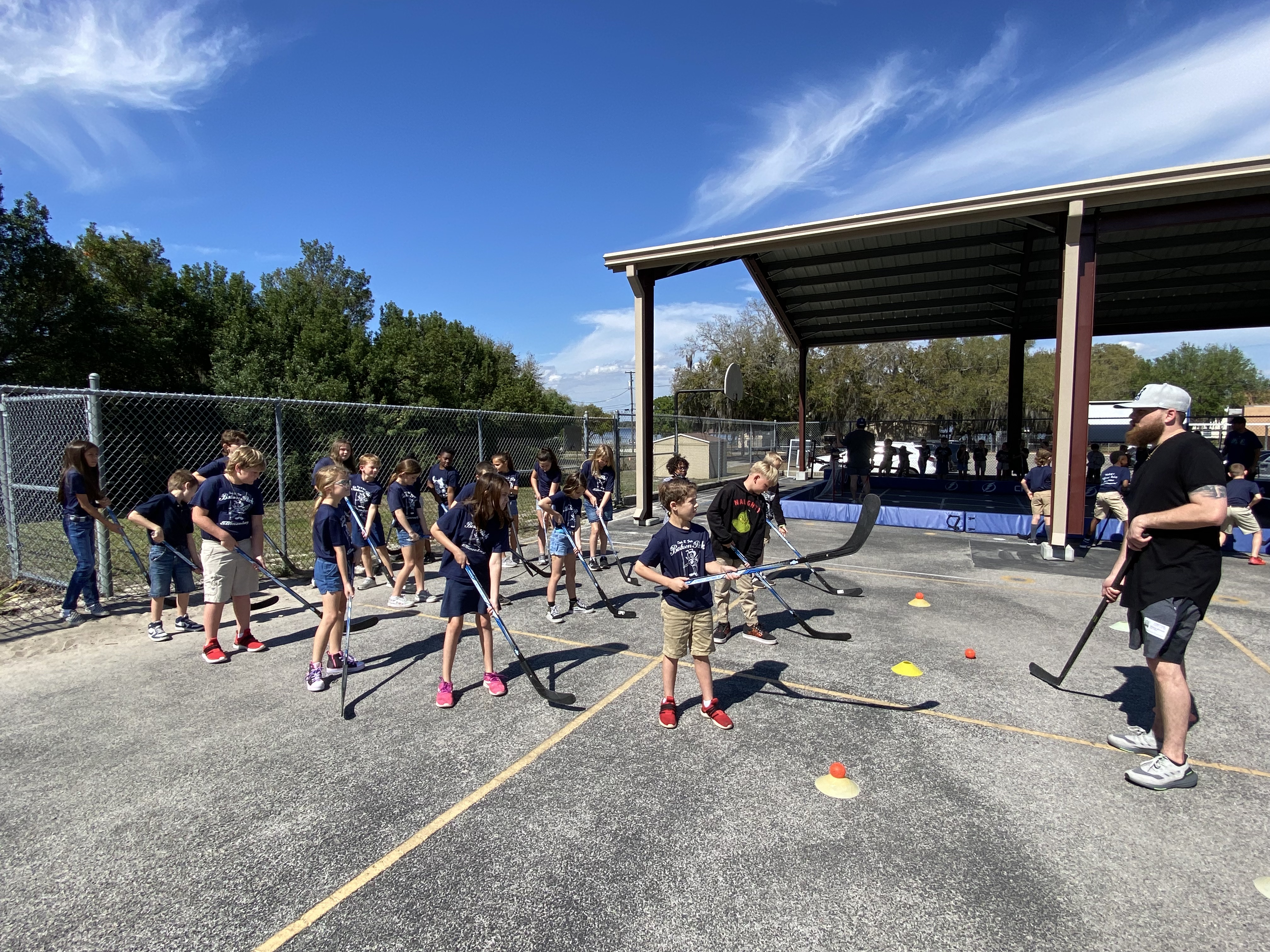 3rd grade students learning hockey techniques.
