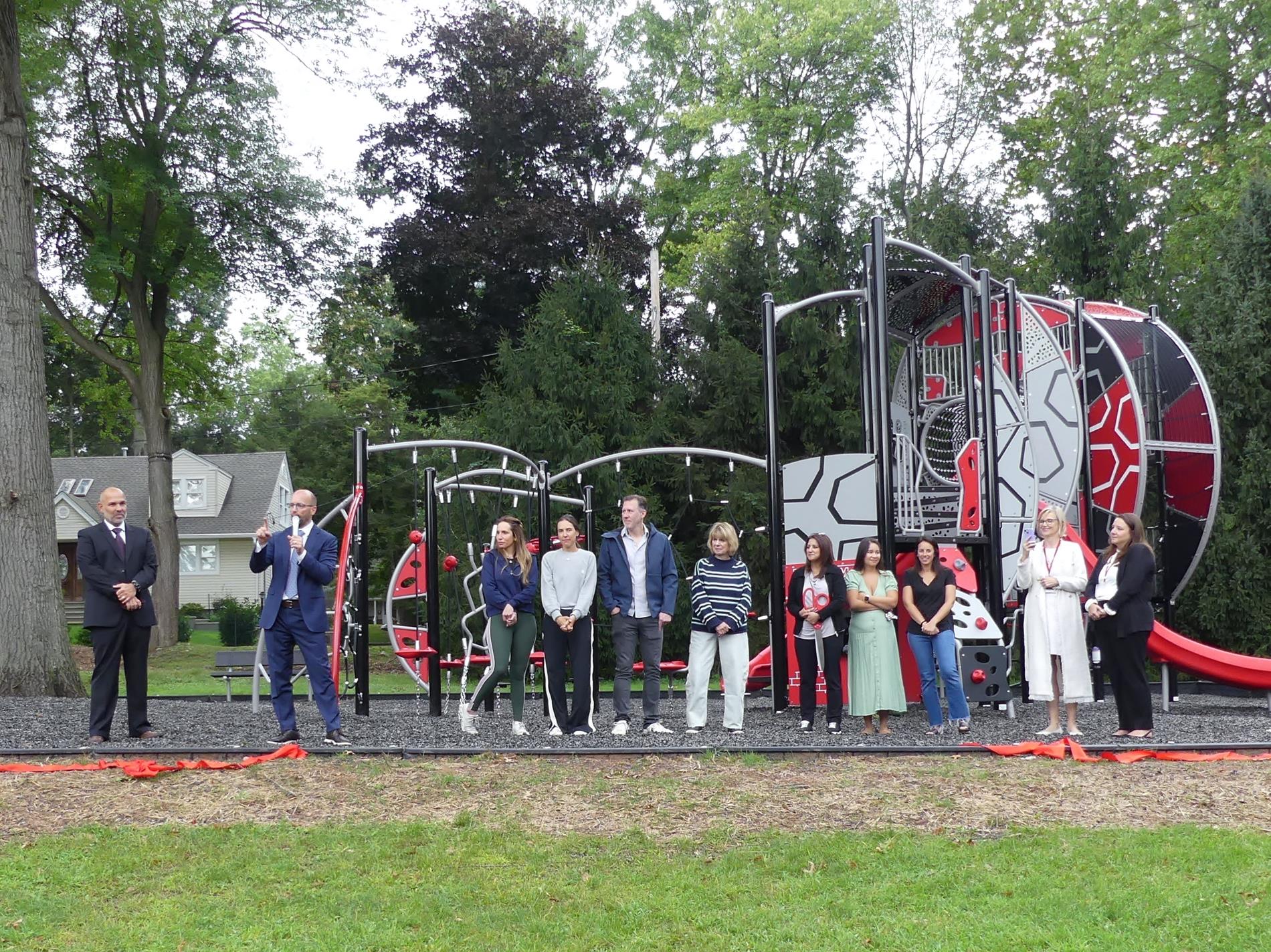 Board of Education members and PTO standing in front of new elementary school playground.