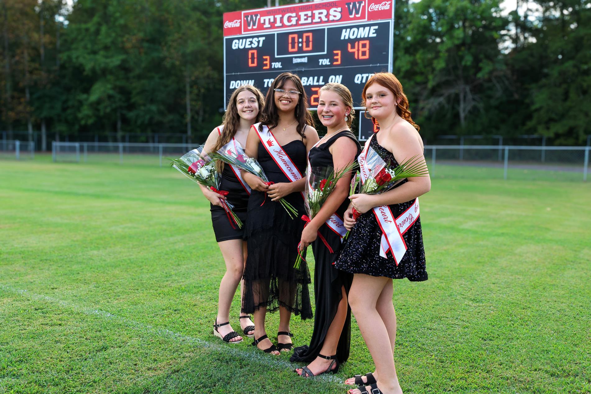 6th grade homecoming court girls in black dresses with red roses