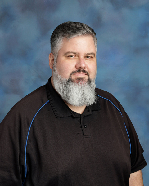 Teacher smiling against a blue background