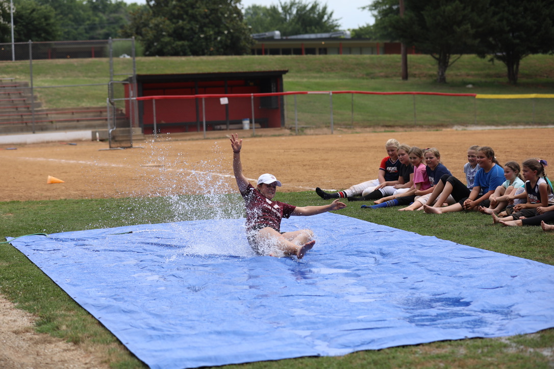 Coach showing students how to slide into base