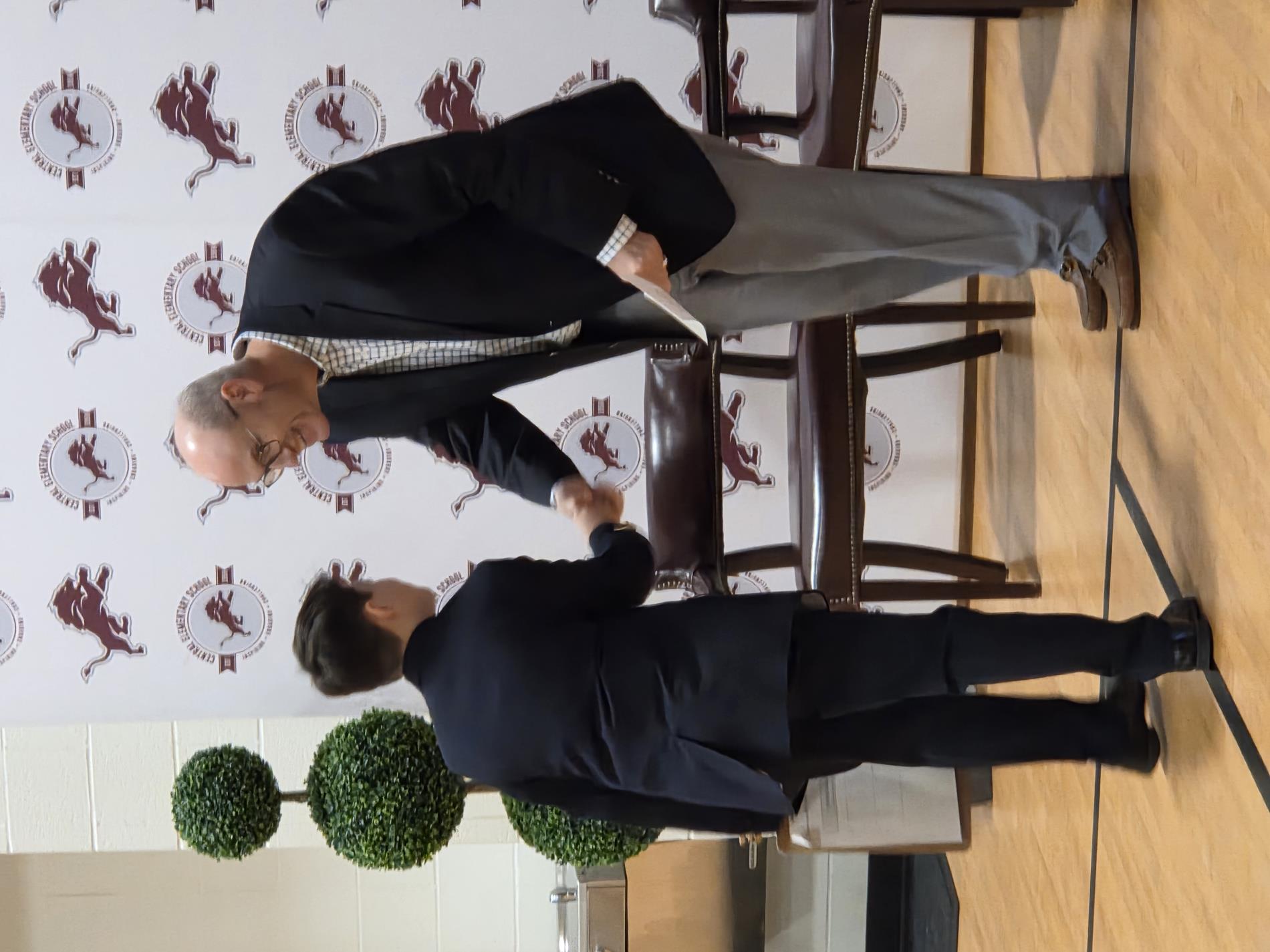 Student and adult shaking hands