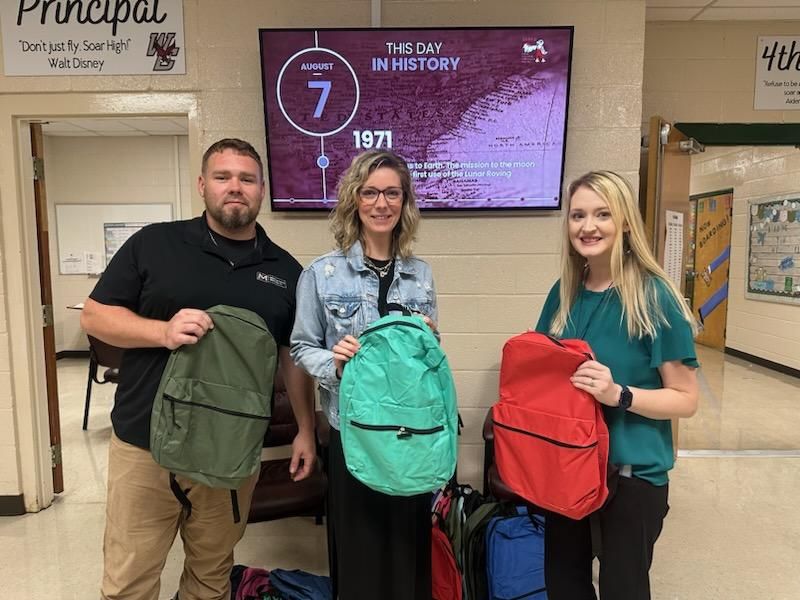 McKenzie Vale Company with principal showing school supplies donated to West Carroll Elementary school