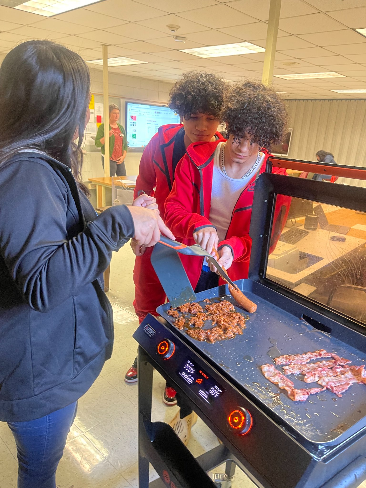 Brothers, Ricardo and Alfredo, and Yimna prepare chorizo for the class.