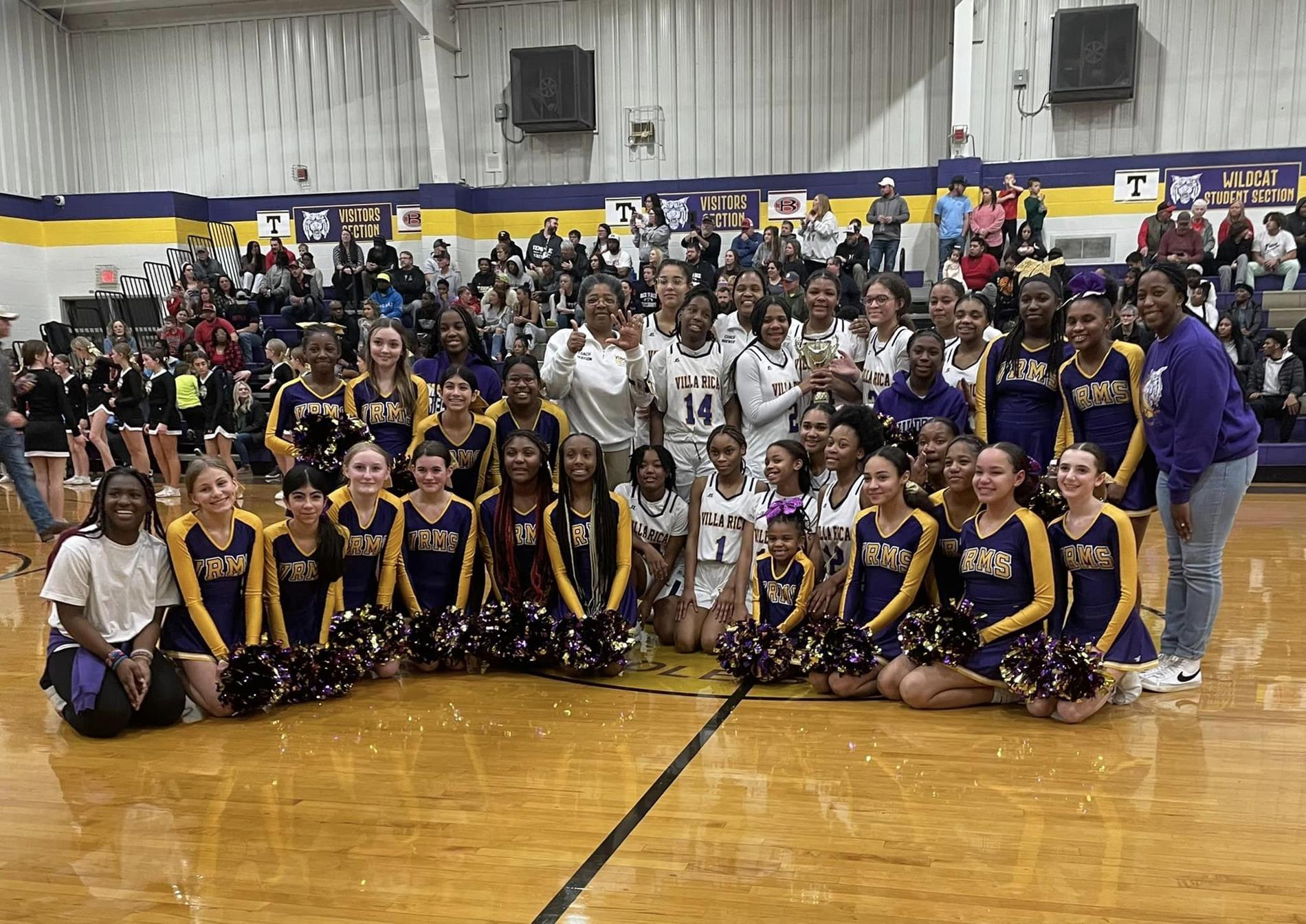 Girls basketball team championship picture with cheerleaders.