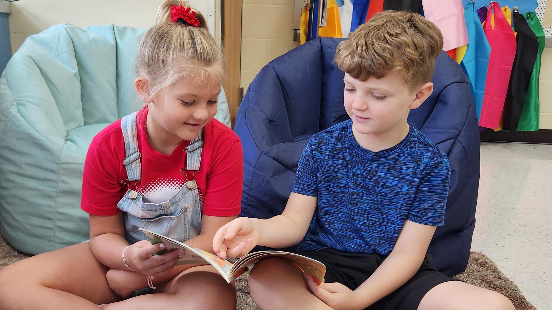 A young boy and girl reading a book together.