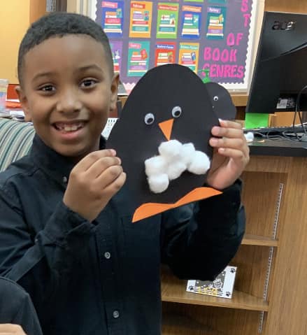 Boy with penguin he made in the library