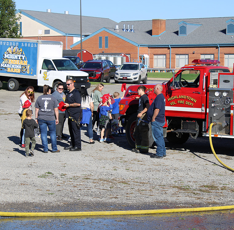 Students see the equipment on the trucks and get their own fire helmet