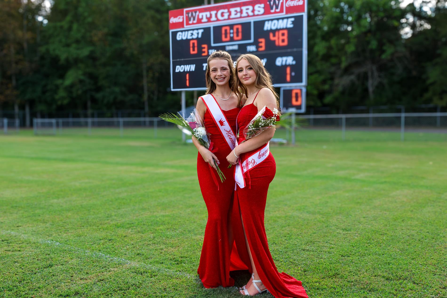 7th grade homecoming court girls in red dresses holding red roses