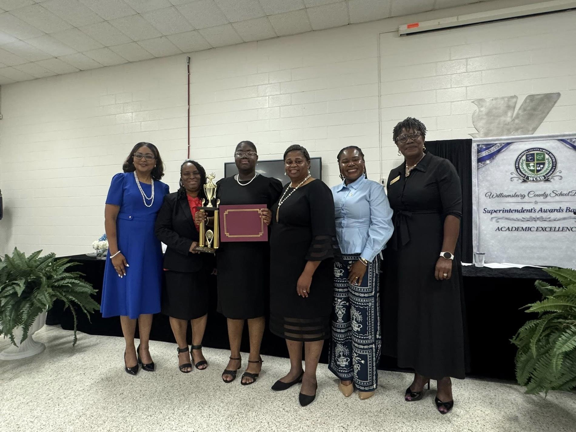 people standing receiving an award. 