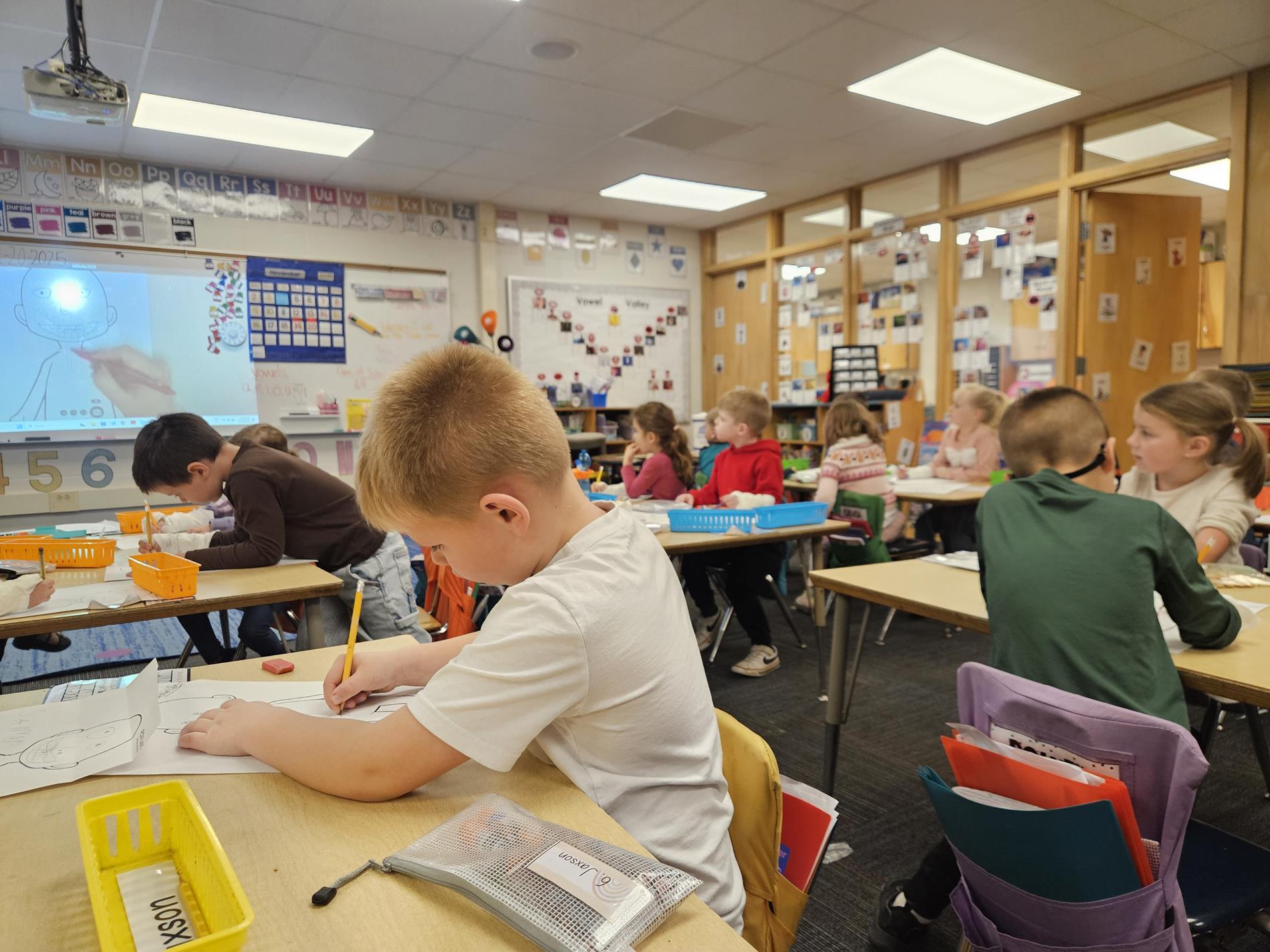 A group of Adams Elementary kindergarteners work at their desks.