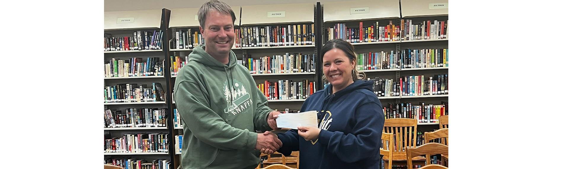 Hampton Lumber donates $20,000 to Knappa Forestry program, and shop teacher Mr. Rathfron receives check.