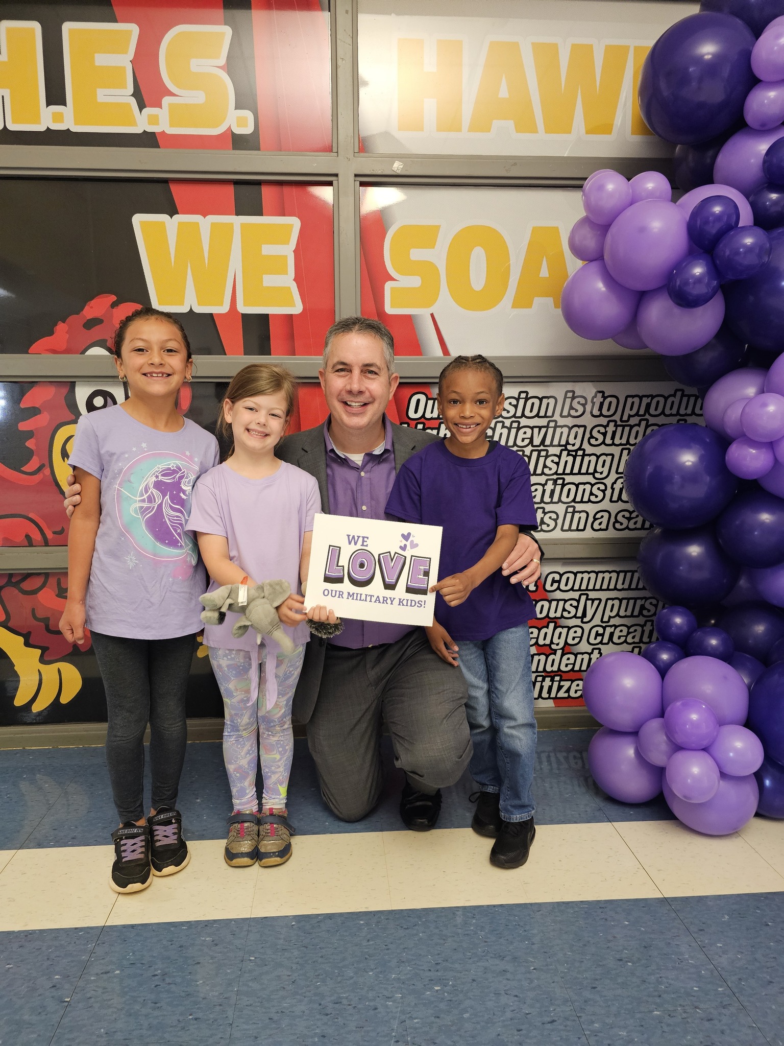 Dr. Rogers and students holding a sign in support of military families
