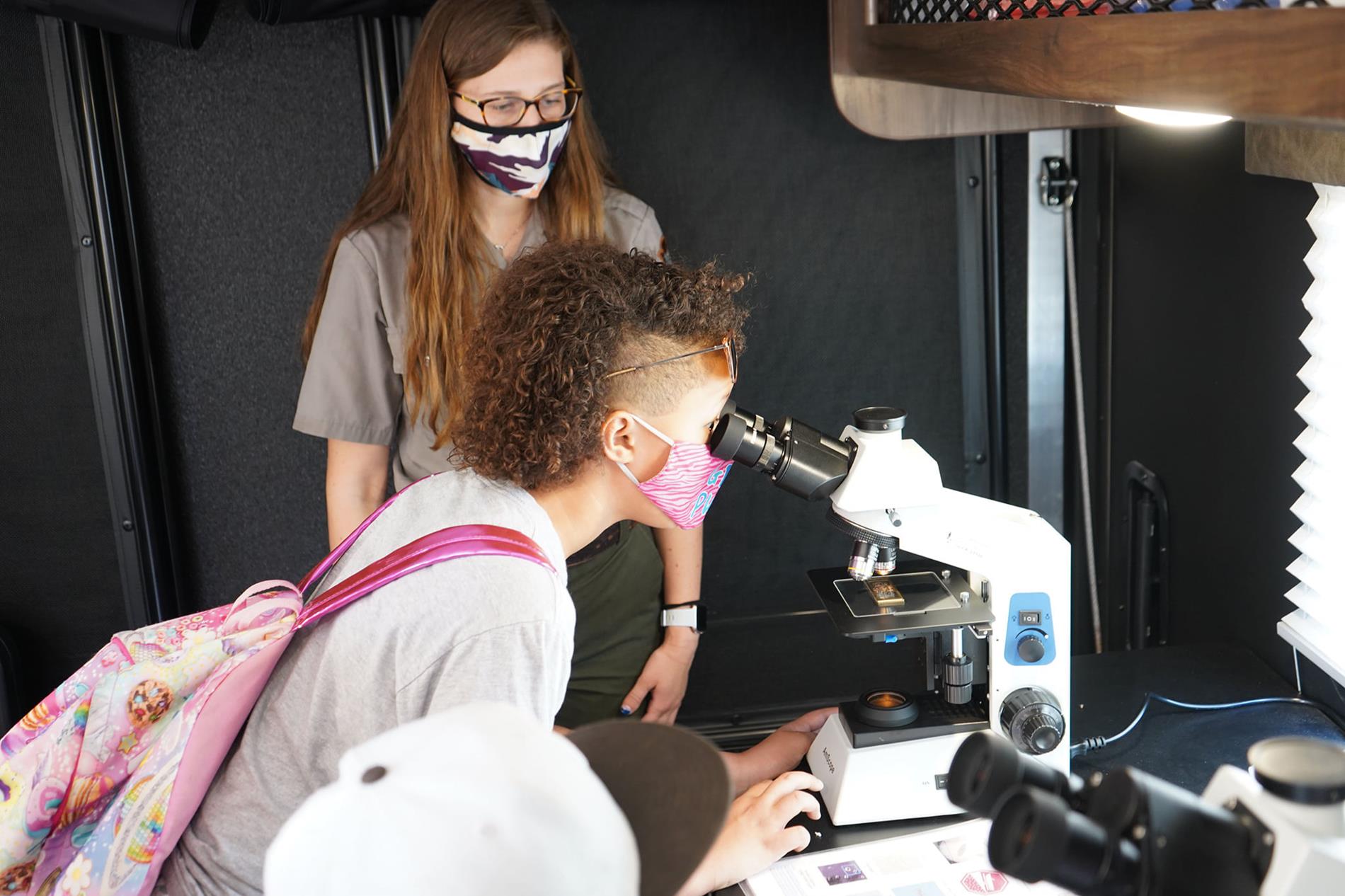 Student looking through a microscope Student looking through a microscope