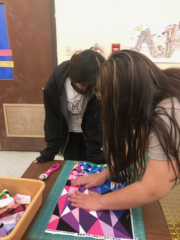 Students helping students to make star quilts 