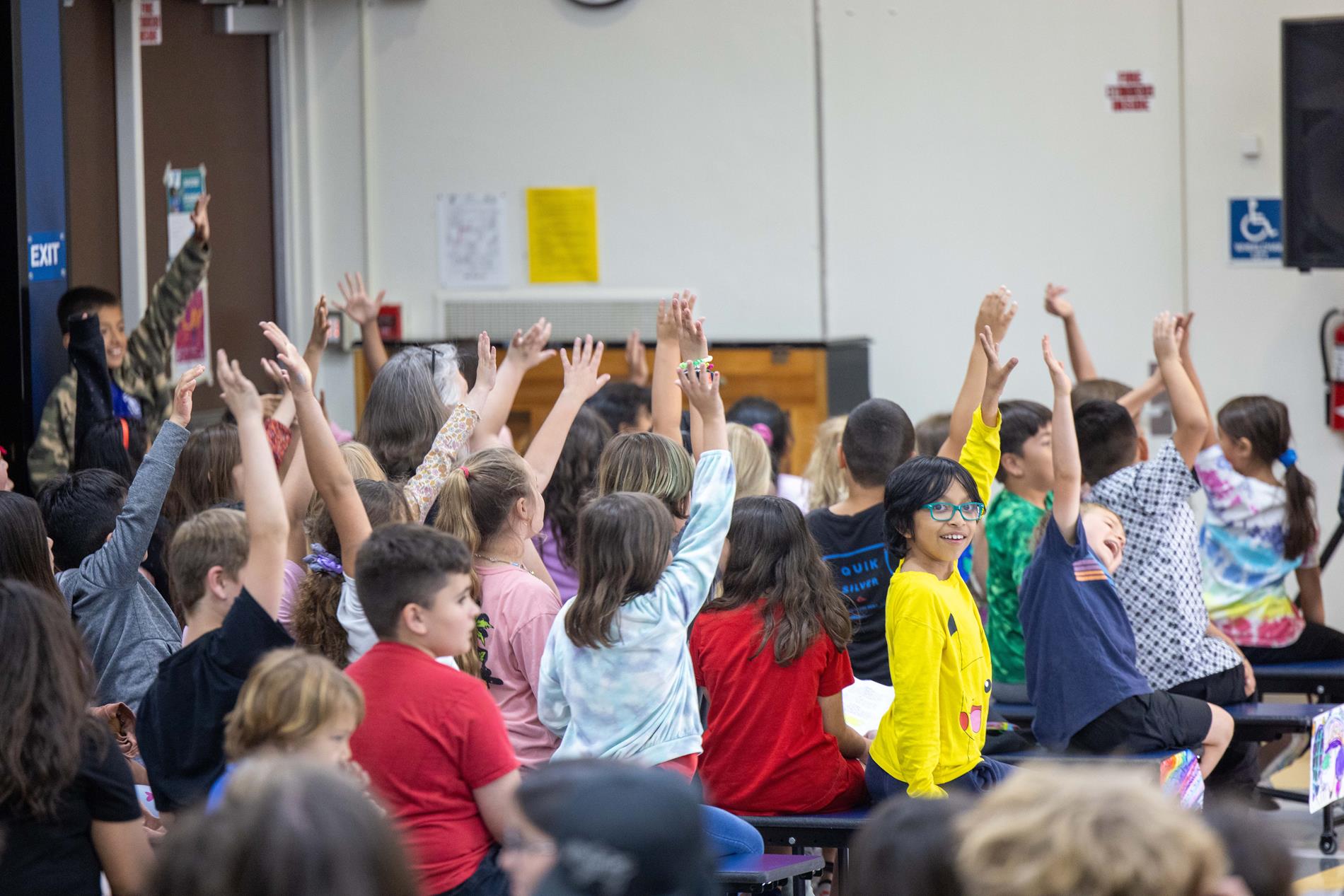 Lots of kids with hands raised