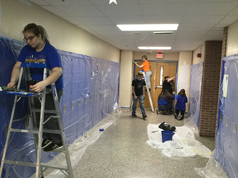 Students volunteering to help paint
