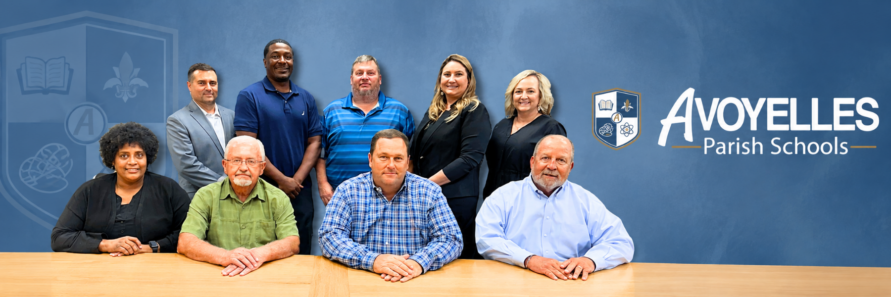 Avoyelles Parish School Board members pose together in two rows against a blue background featuring the Avoyelles Parish Schools logo.