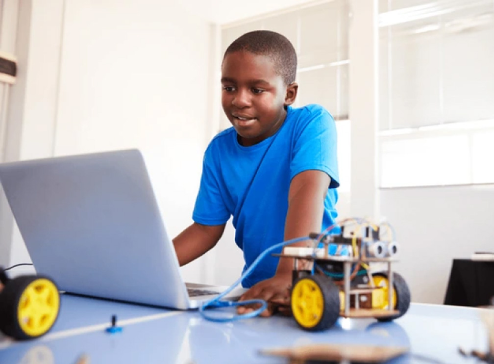 Young Man at laptop with robot