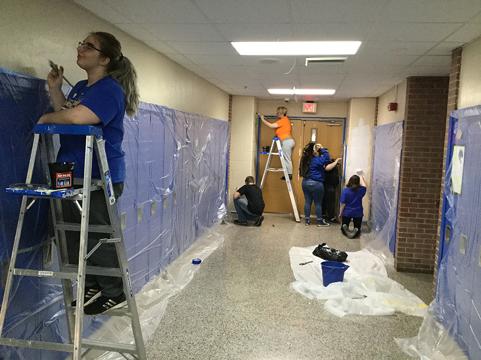 Students volunteering to help paint