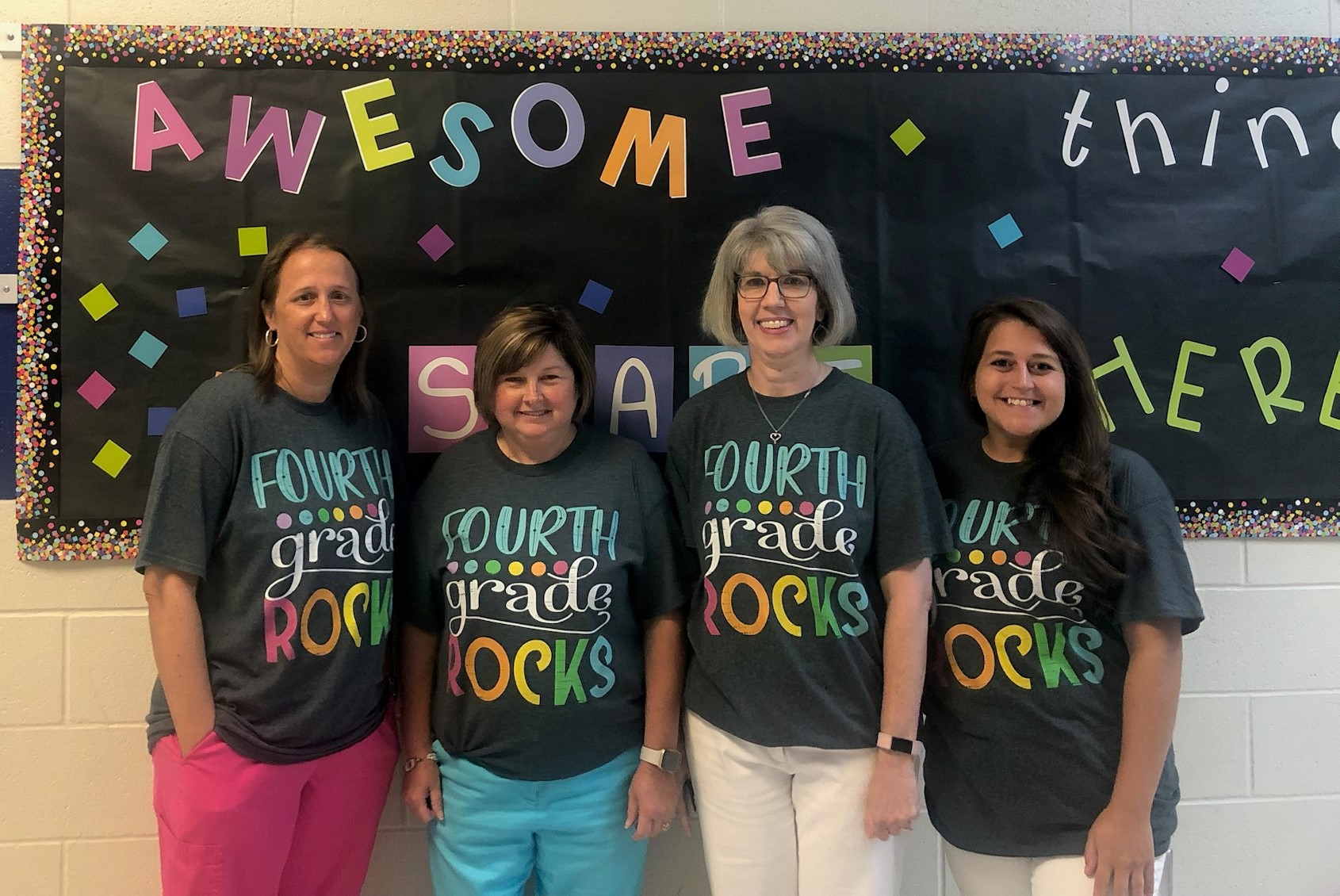Teachers wearing a 4th grade rocks t-shirt.