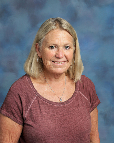 Teacher smiling against a blue background