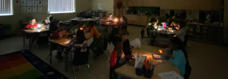 students reading by flashlight during Celebrate Literacy Week