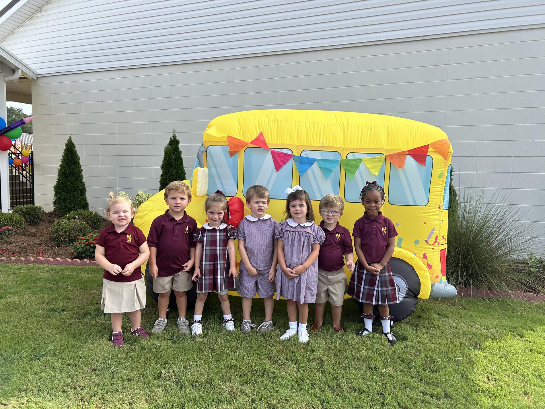 Pre-K3 children in front of a bus cutout