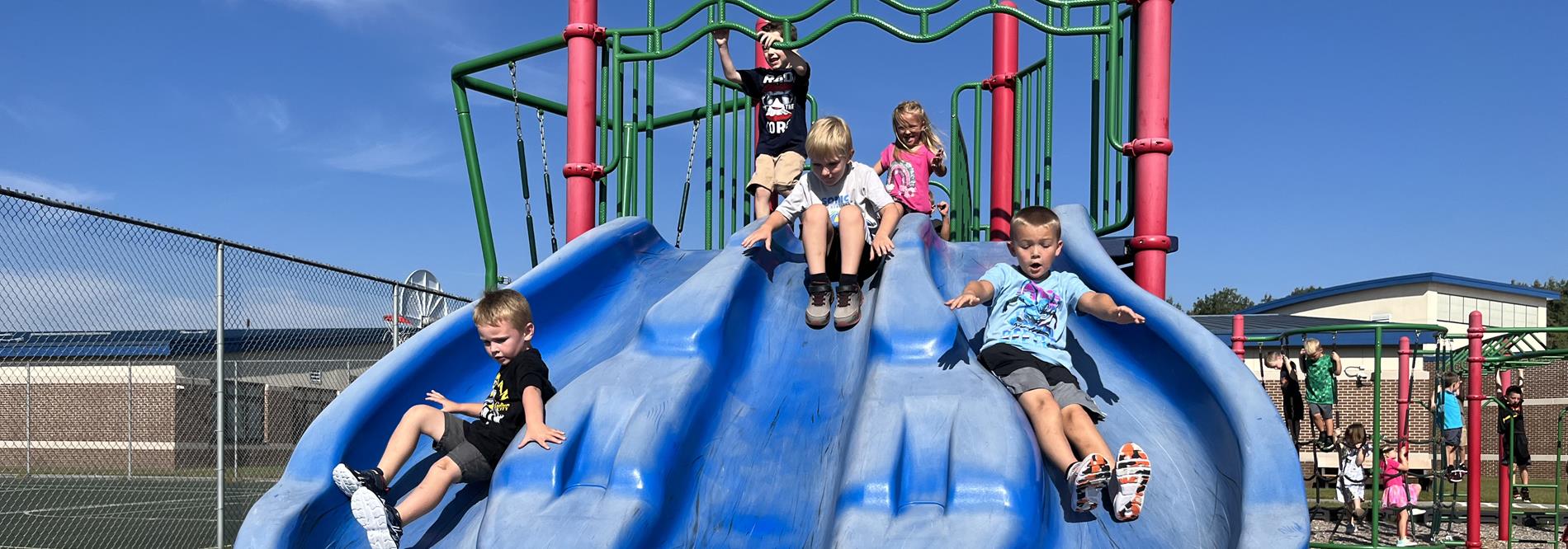 three boys on slide