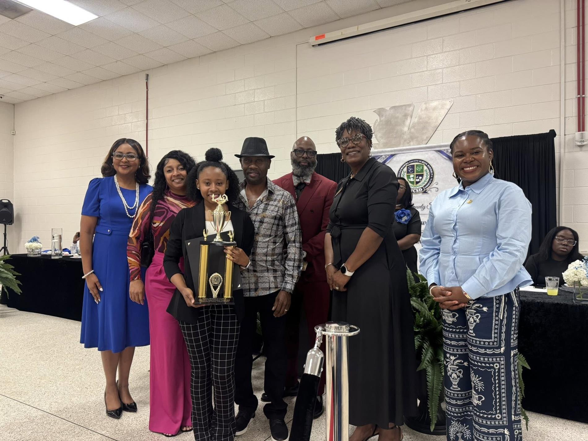 people standing together. one is receiving an award 