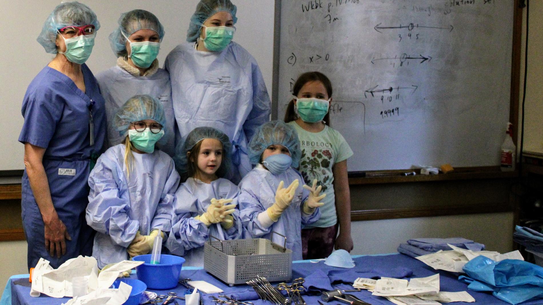 Children dressed in surgical PPE as part of a surgery presentation.