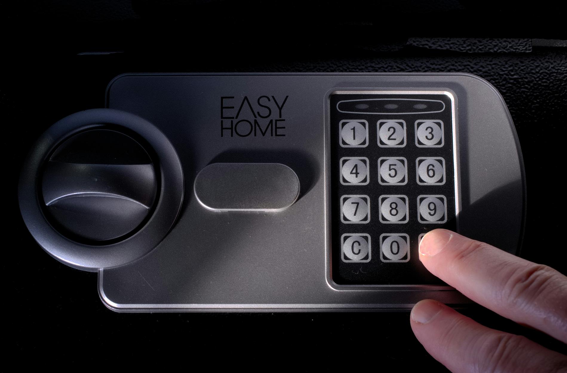 A hand pushing buttons on a home safe