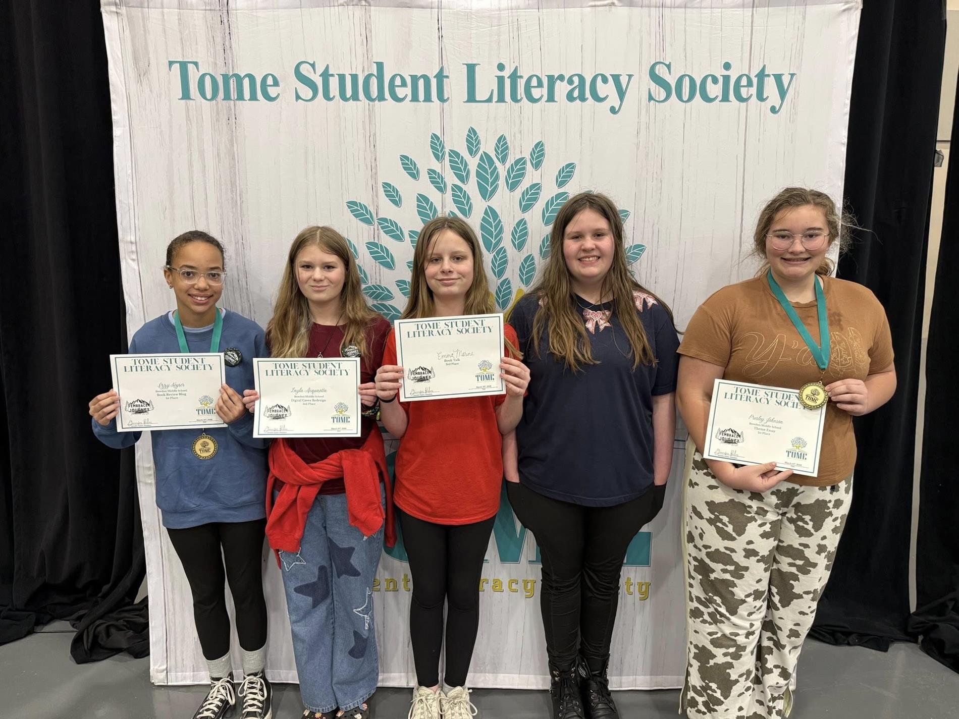 Photo of the 2026 TomeCon project winners posing with certificates in front of a TomeCon backdrop