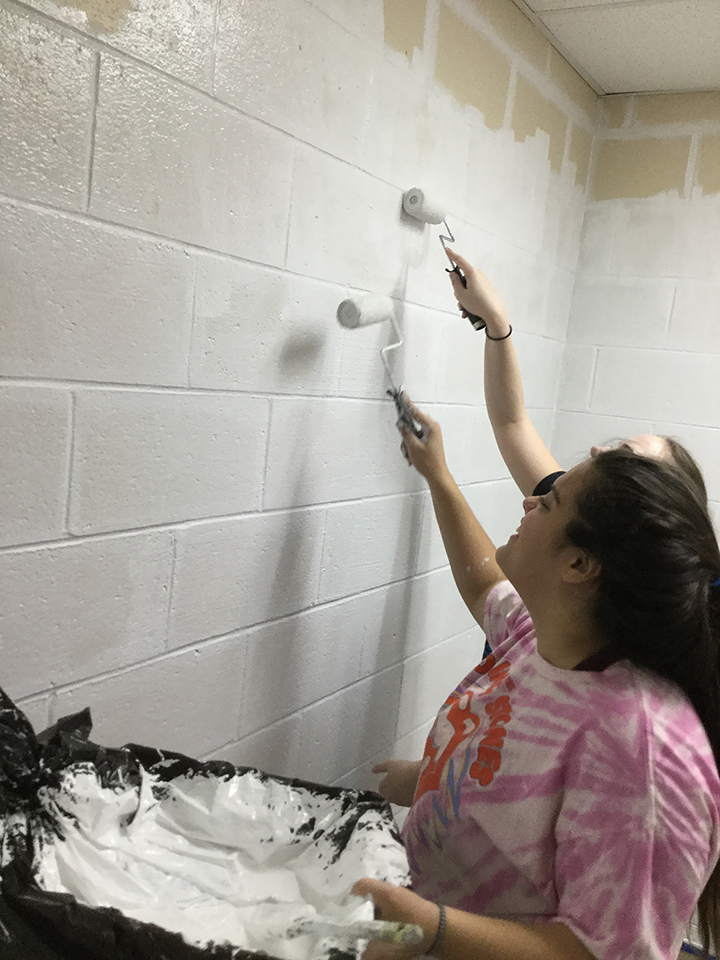 Students volunteering to help paint