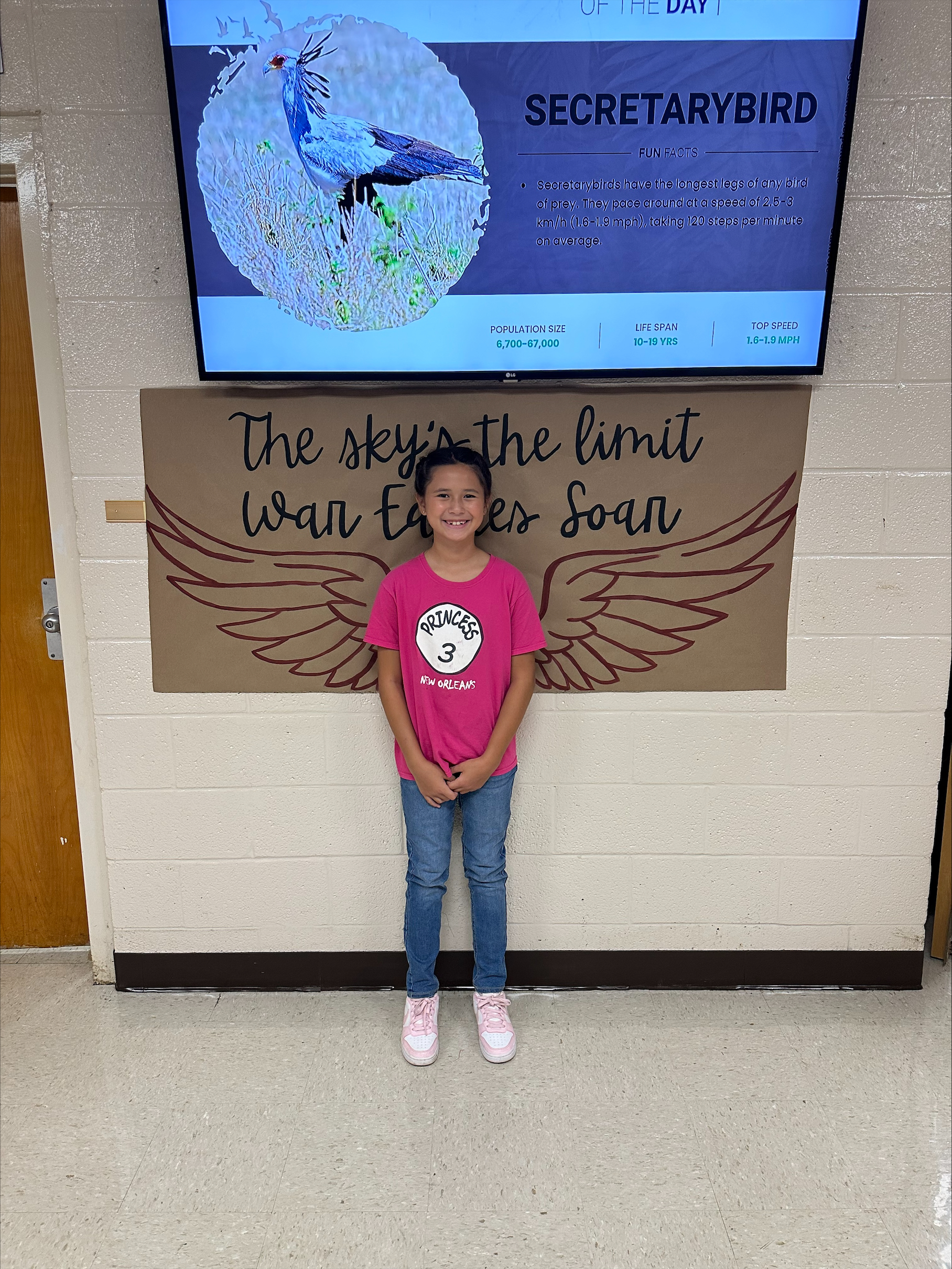 WCES student standing in front of banner on open house evening