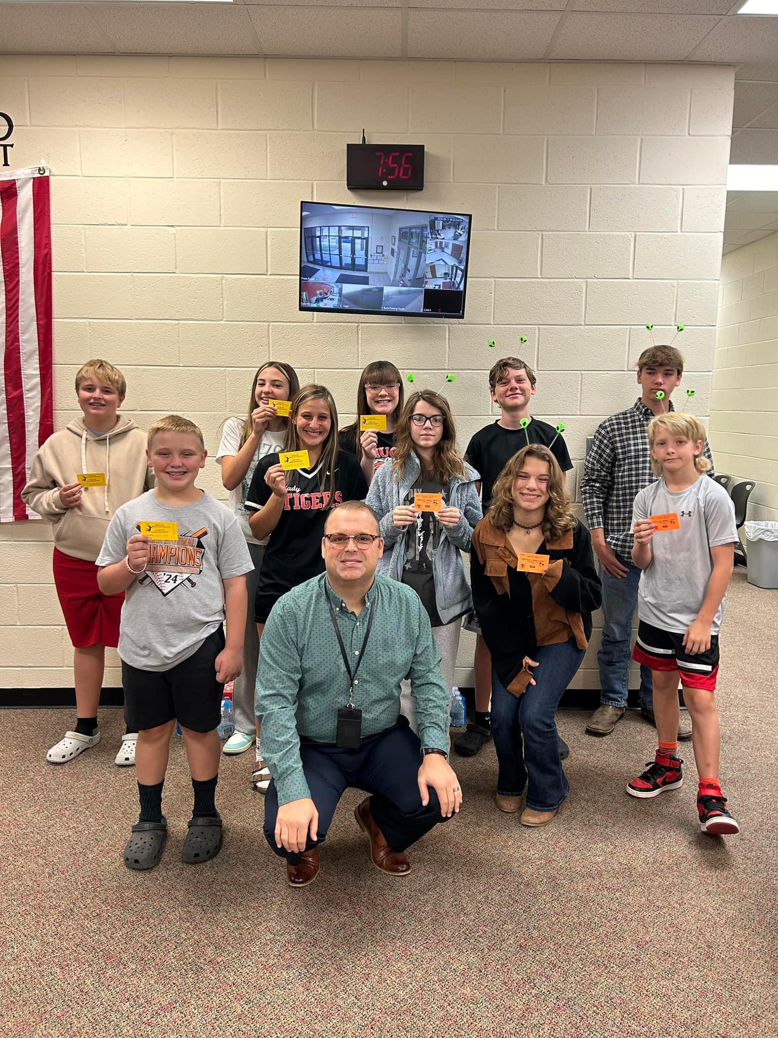 Students with principal holding tickets for basketball show